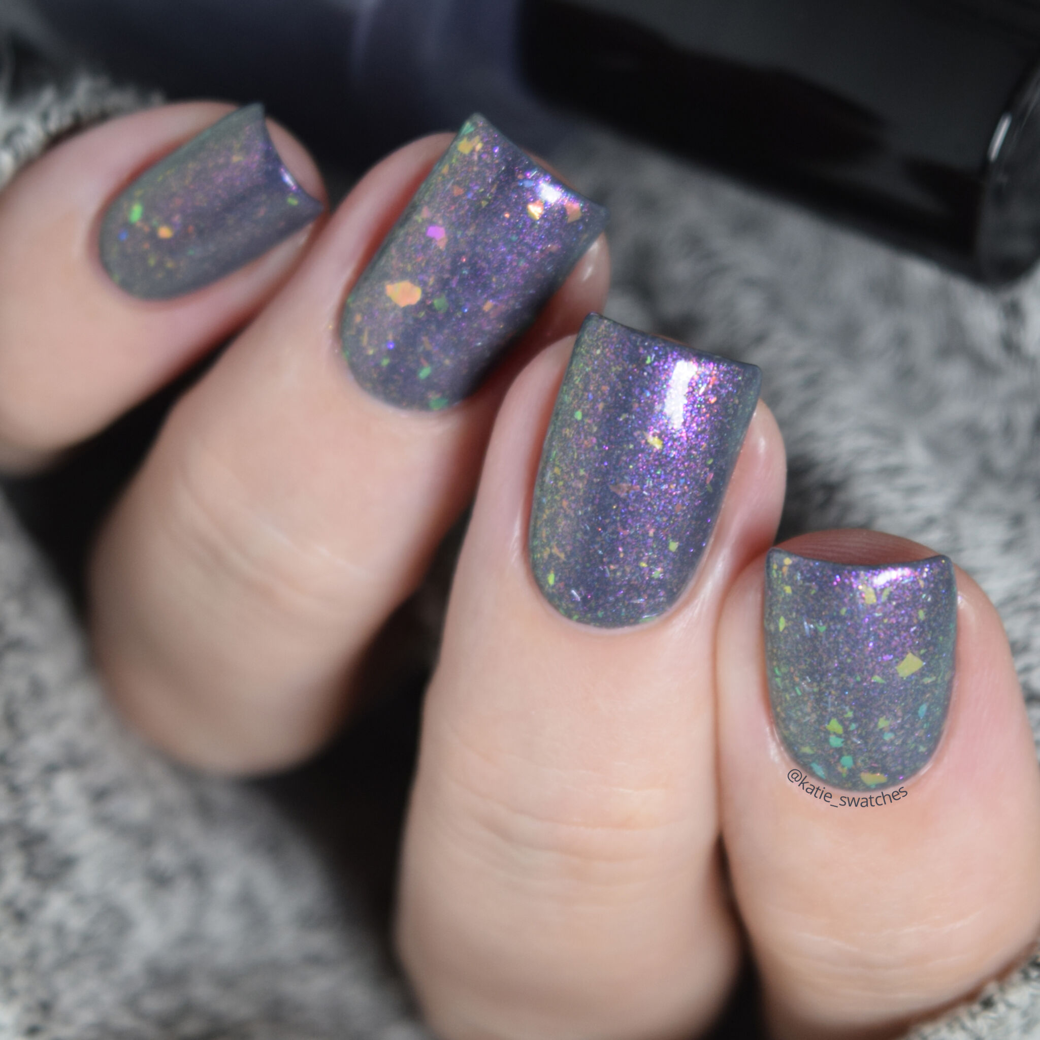 Girly Bits - Thistle While You Work shimmer flakie layered over I'm Pun-decided charcoal creme nail polish swatch