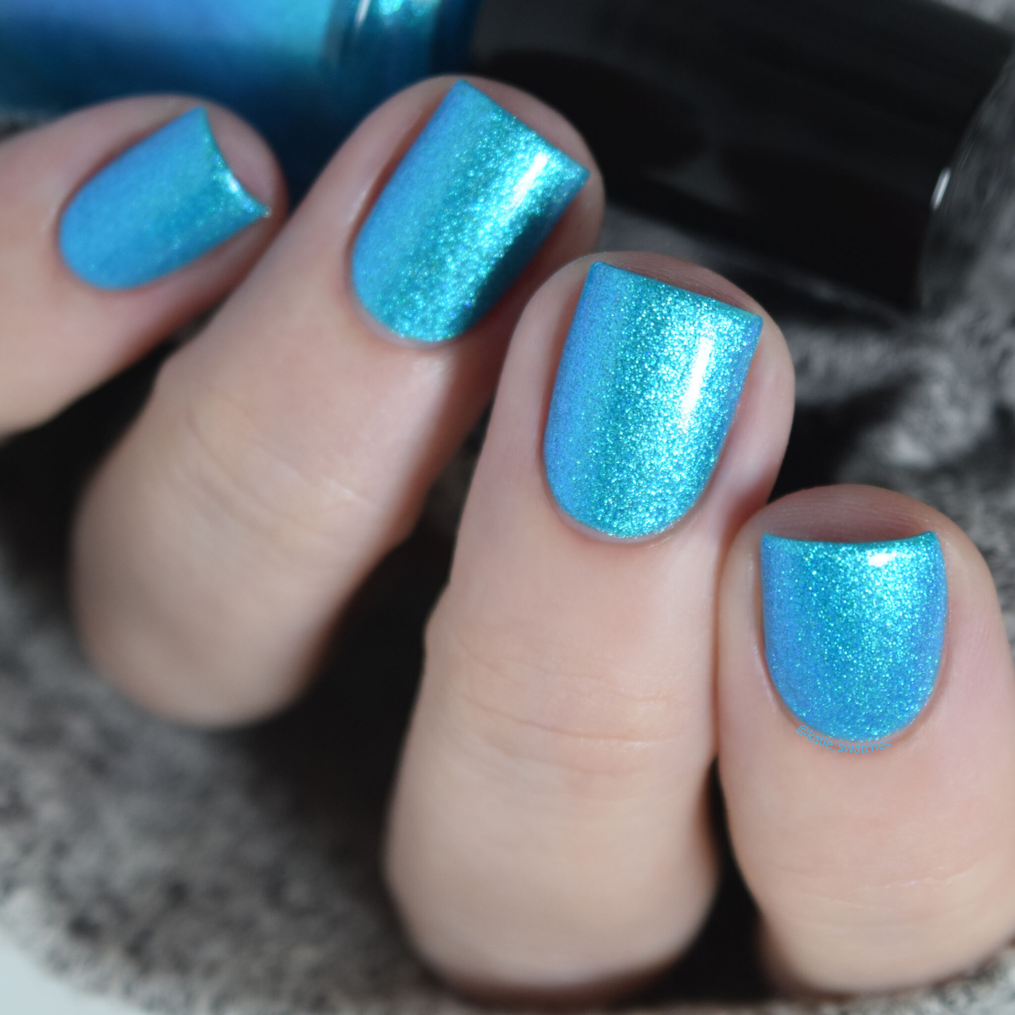 Girly Bits - Lorraine nail polish swatch, with top coat, from the Misheard Lyrics Collection. bright aqua/cyan blue nail polish with a blue/purple shimmer