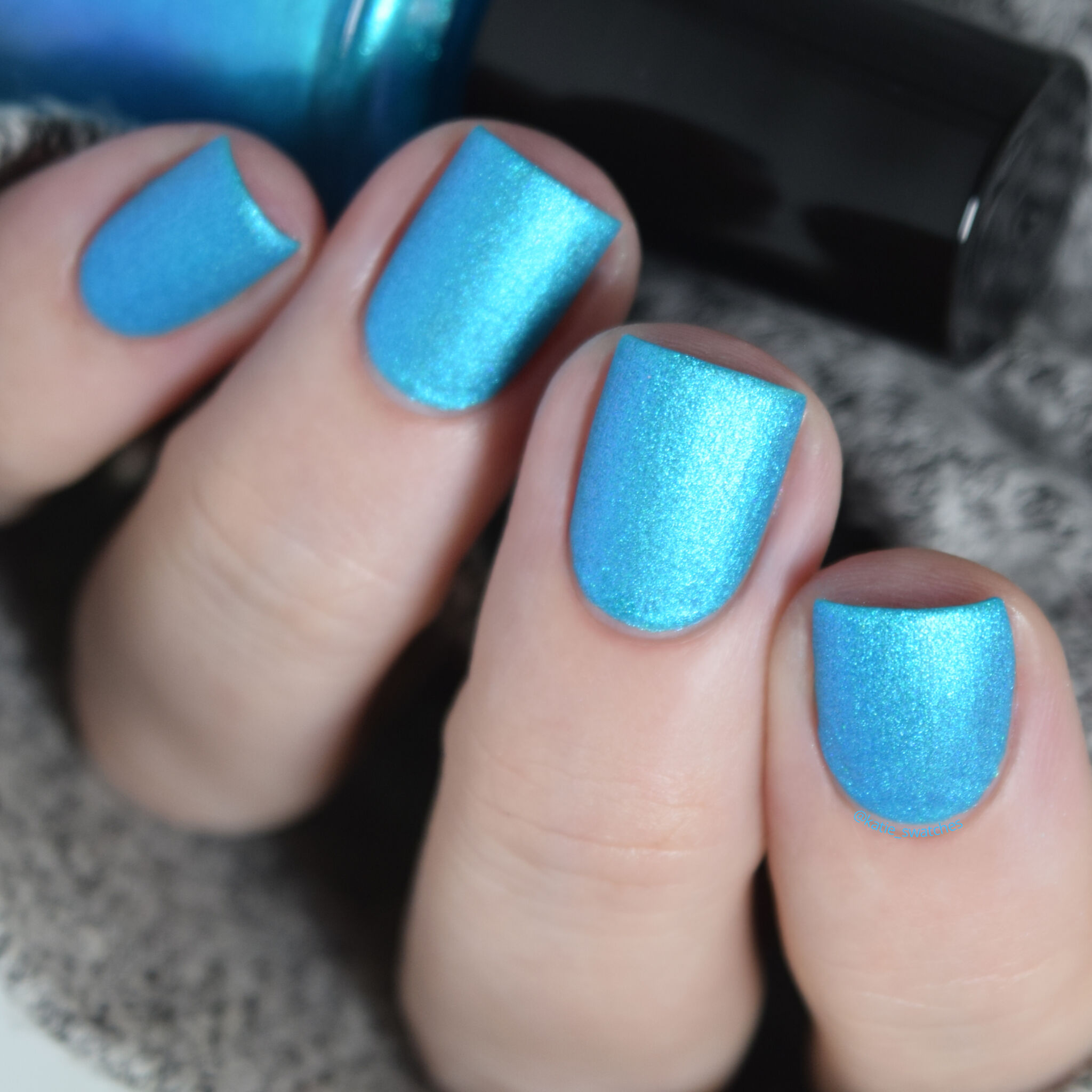 Girly Bits - Lorraine nail polish swatch from the Misheard Lyrics Collection. bright aqua/cyan blue matte nail polish with a blue/purple shimmer